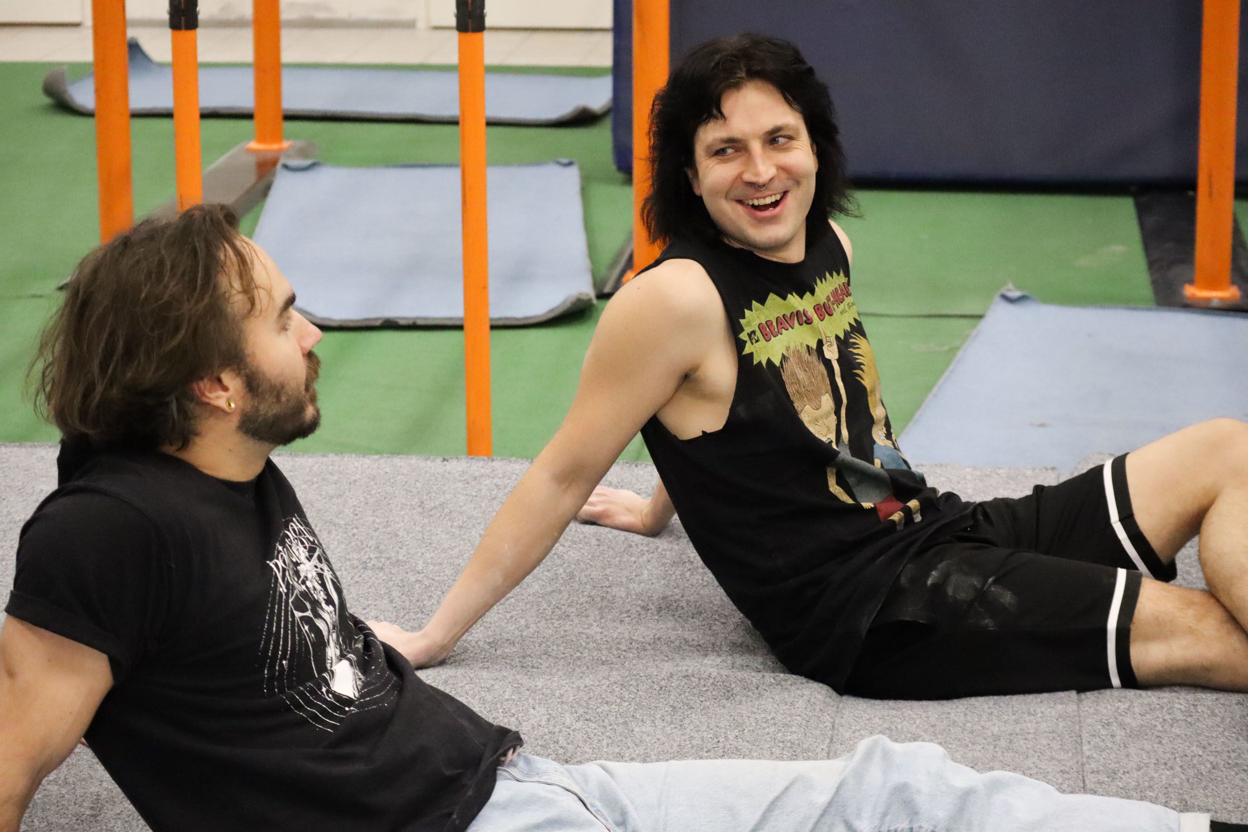 Kaksi kaverusta istuu kiipeilyhallilla ja juttelee