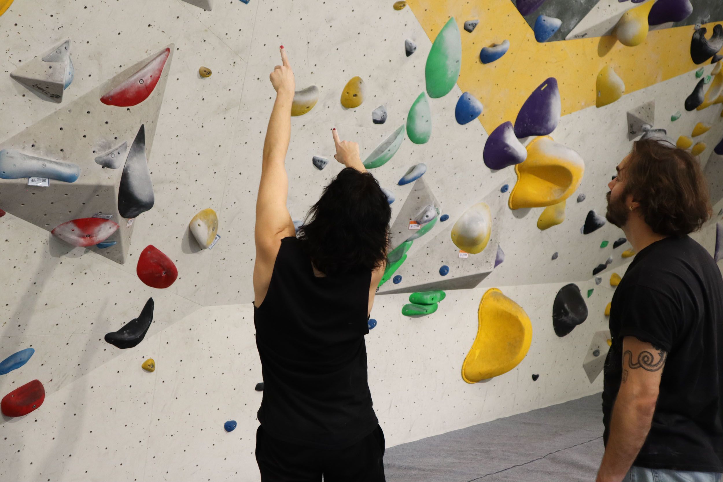 Kaverukset juttelevat ja osoittavat kiipeilyseinää