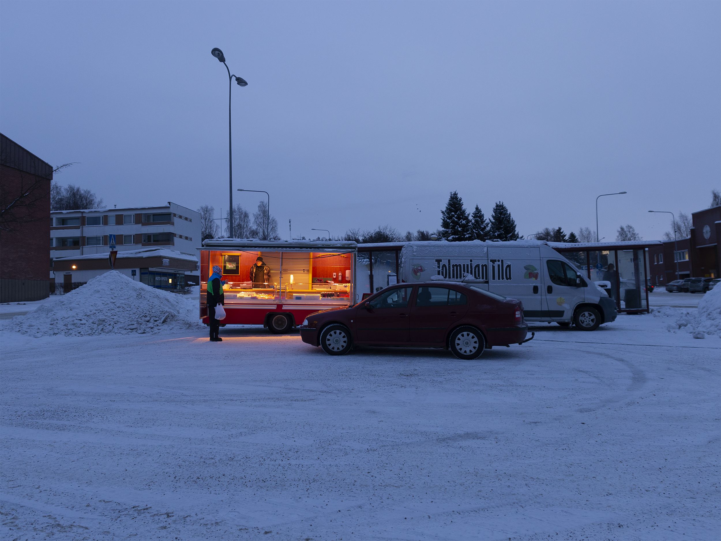 Kuvassa on Tolmulan tilan myyntiauto ja myyntivaunu Suolahden torilla. On aamuhämärä tammikuussa. Paljon lunta ja pakkasta.