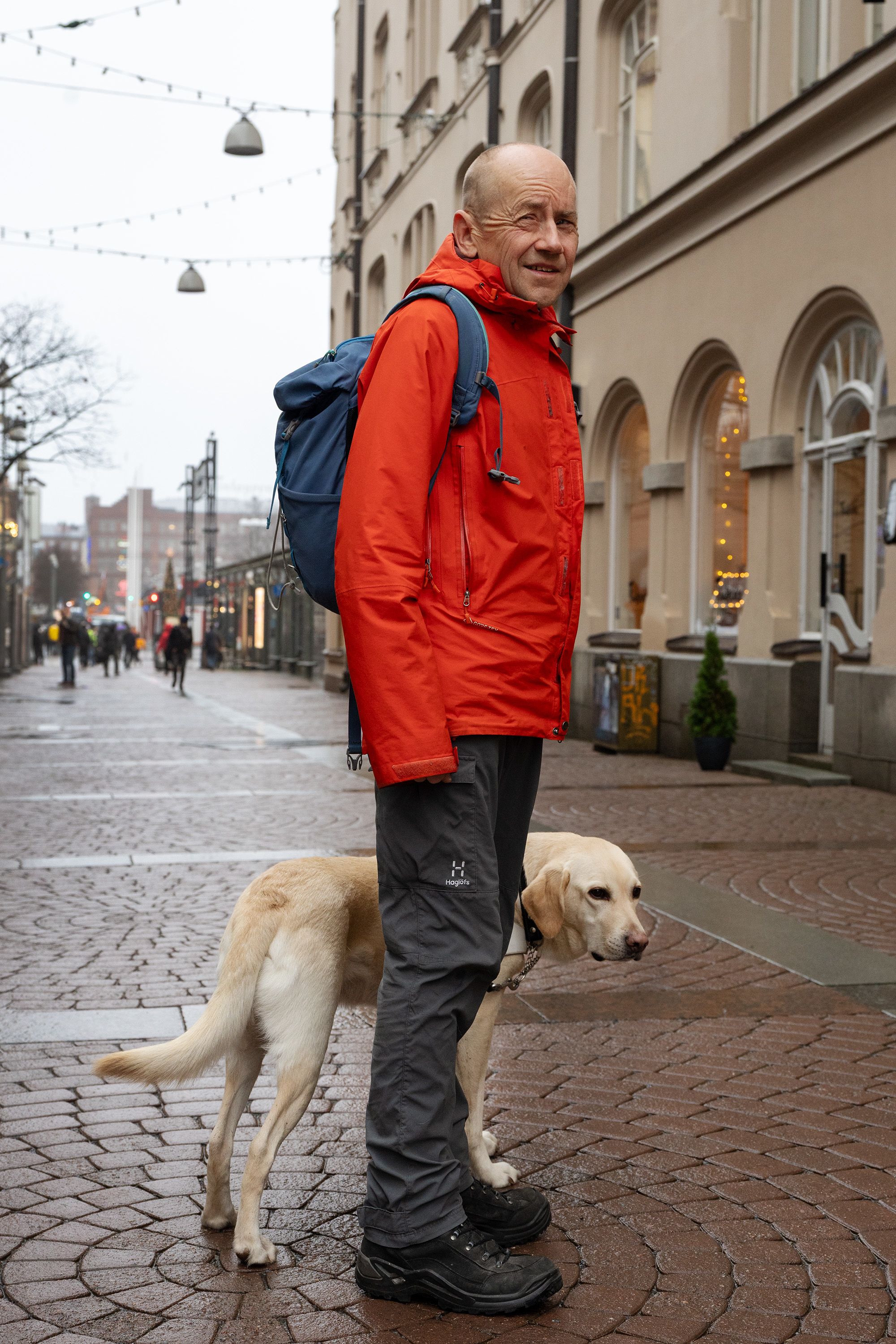 Janne Silas ja Patu-koira seisovat kävelykadulla Tampereen keskustassa.