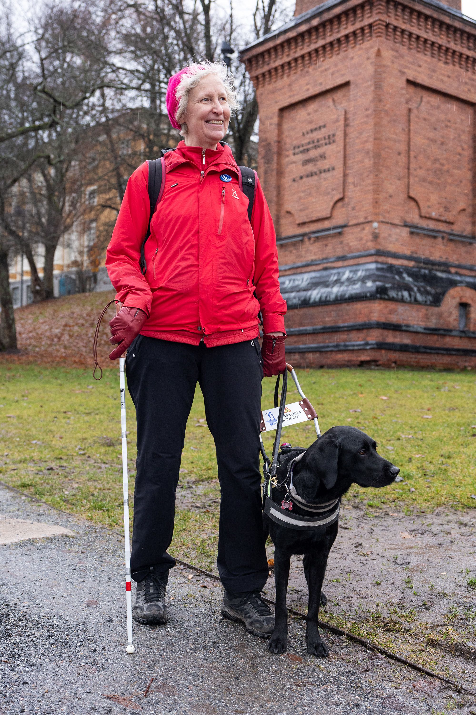 Outi Lehtinen ja Pepsi-koira seisovat puistossa Tampereen keskustassa.