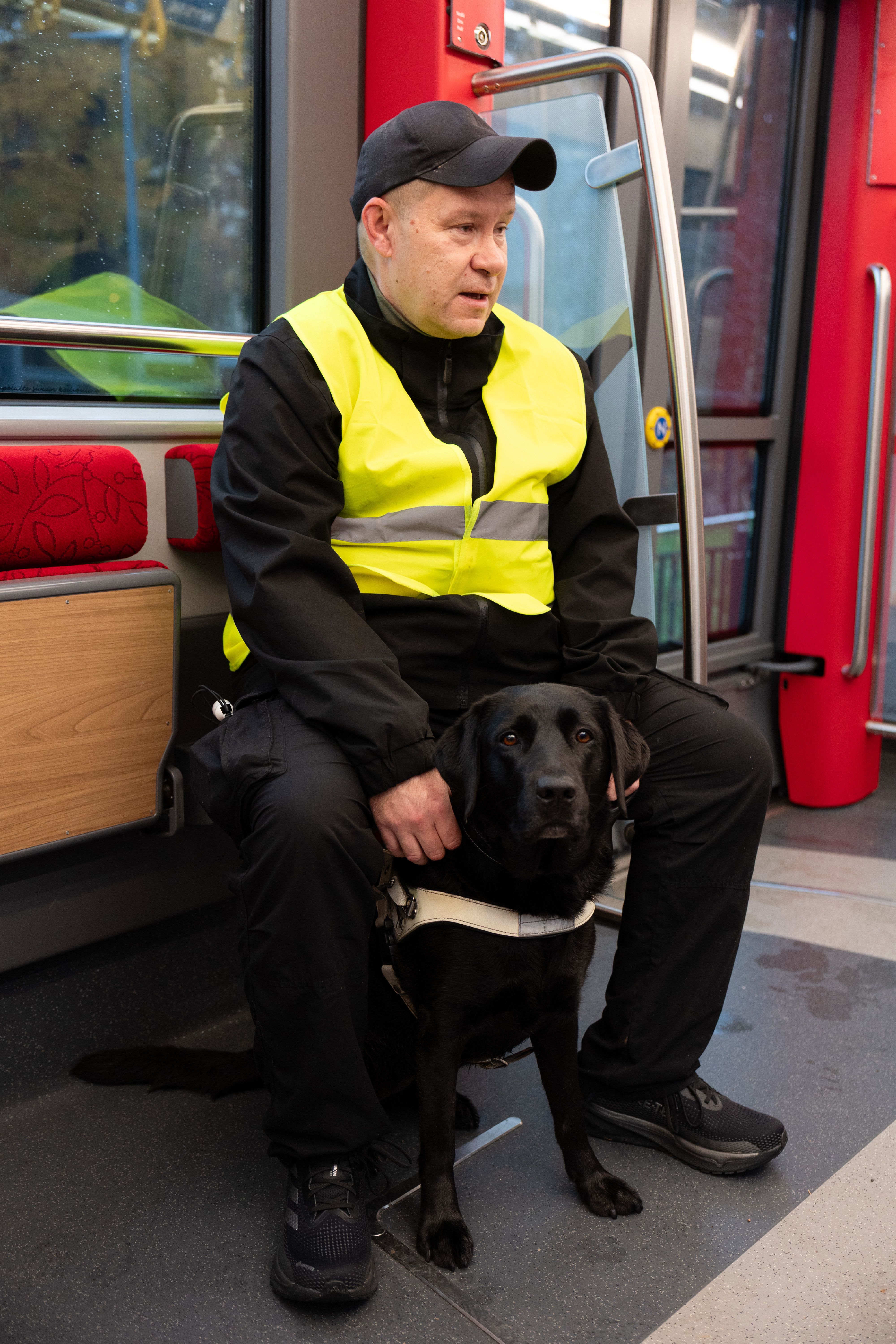 Tommi Jyväkorpi ja Talvi-koira istuvat raitiovaunussa.