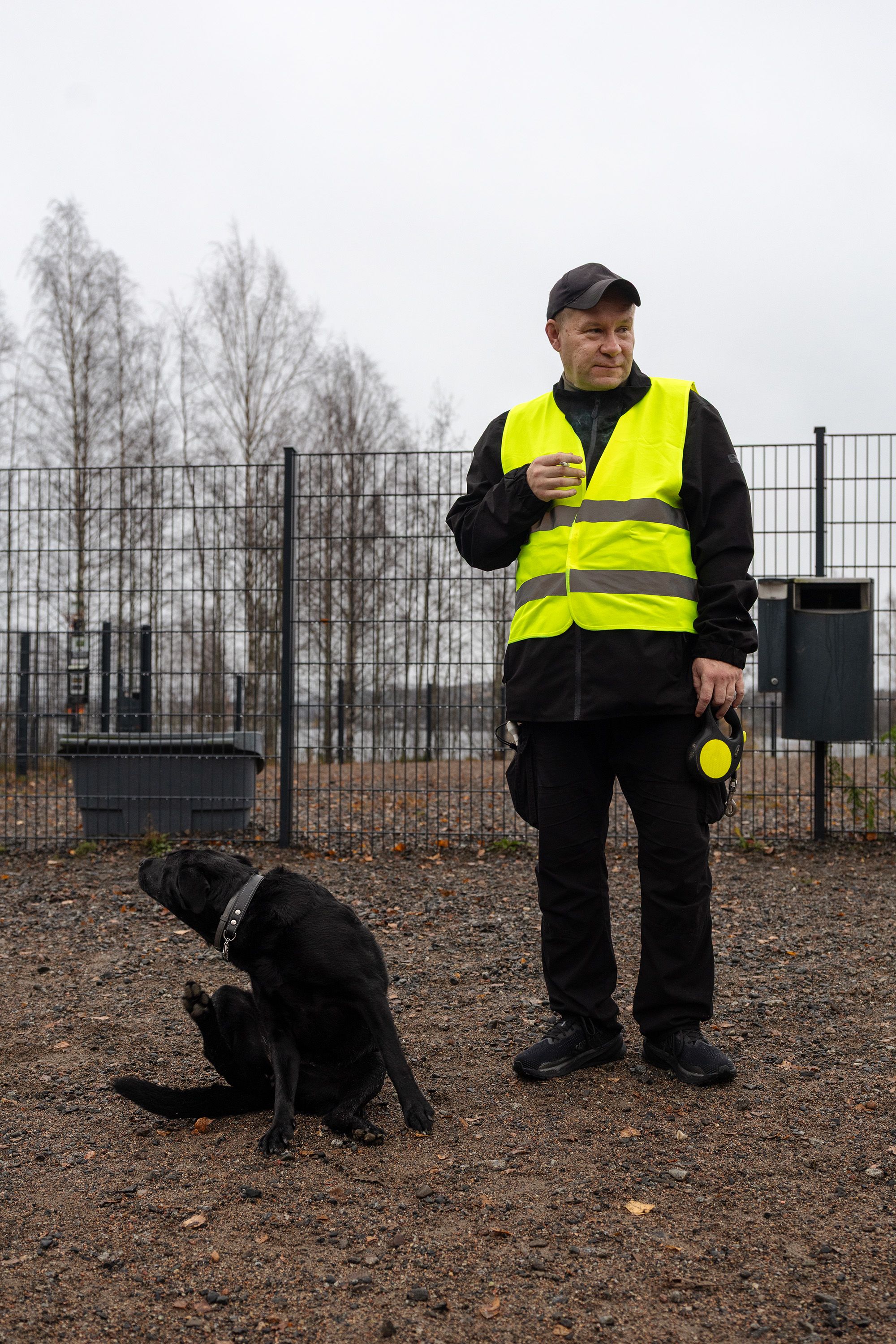Tommi Jyväkorpi ja Talvi-koira vierekkäin koirapuistossa. Talvi rapsuttaa korvaansa.