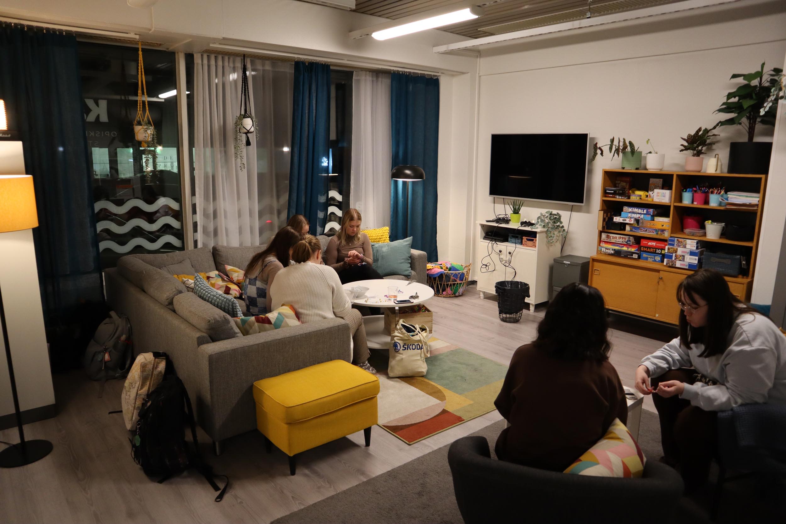 Kävijät viettävät aikaa Kamulan olohuoneessa.