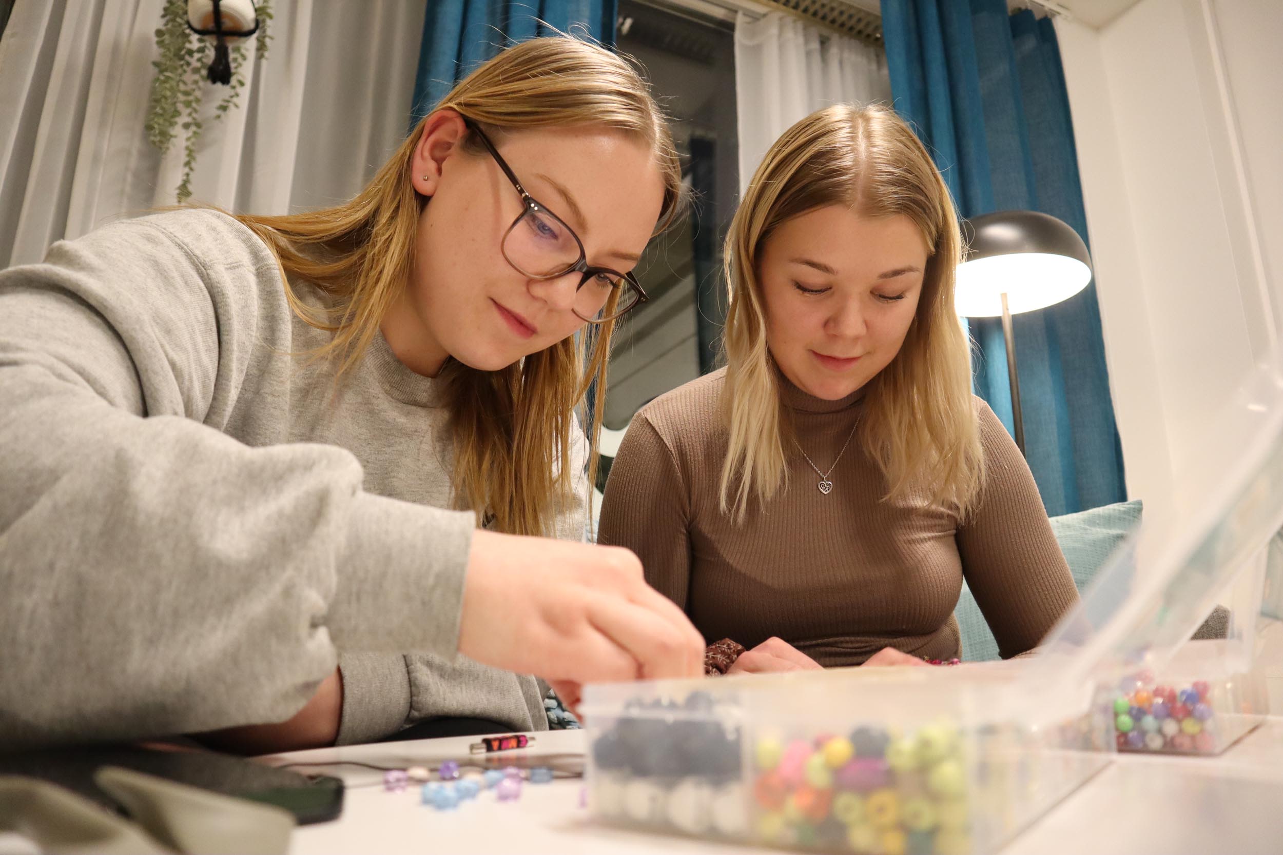 Kamulan kävijät Saara ja Viivi askartelevat koruja.